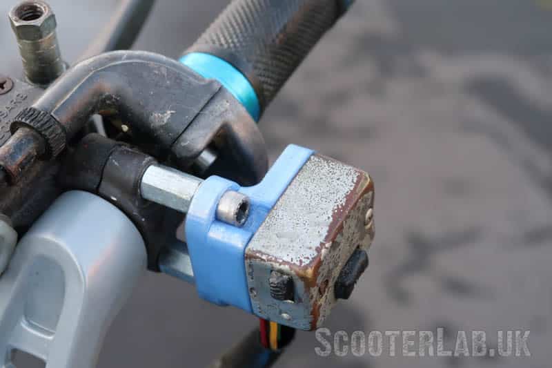 3D-printed bracket allows the original Lui switch to fit onto studs and long nuts fitted to the master cylinder bracket