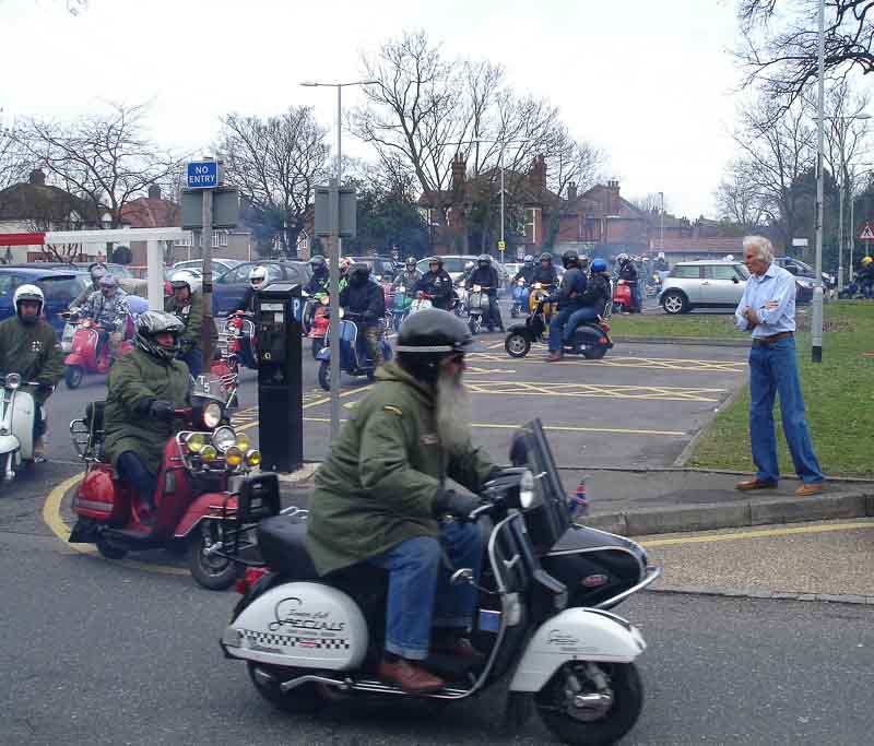 Local scooterists gathered near the shop for a tribute to Roy when the shop closed for the last time - Roy watches them pass