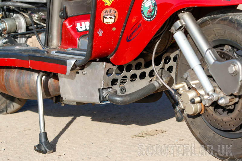 Air enters through holes in the belly pan and exits downwards through the horizontally-mounted radiator